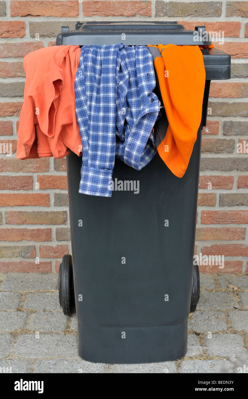 Clothes hanging out of a bin Stock Photo