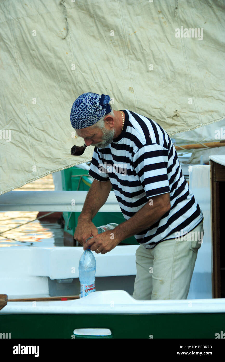 Sailor smoking pipe on his yacht in Vrboska on Hvar Island, Croatia Stock Photo