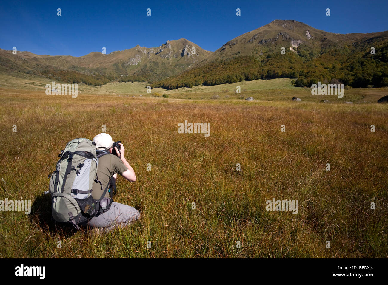 A hiker photographing the "Fontaine salée" Cirque (Puy de Dôme-France). Randonneur photographiant le Cirque de la Fontaine Salée Stock Photo