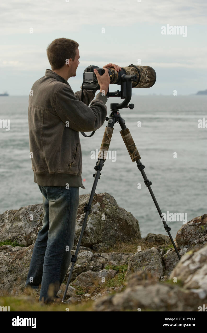 Nature Photographer Peter Moonlight using a super telephoto lens and a digital SLR (DSLR) on the Welsh coast. Stock Photo