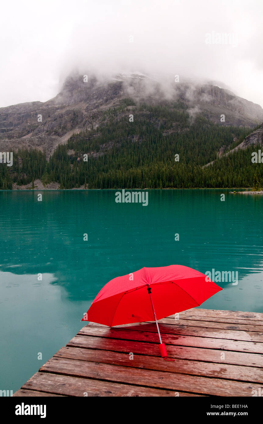 red umbrella with emerald lake water and dock Stock Photo Alamy
