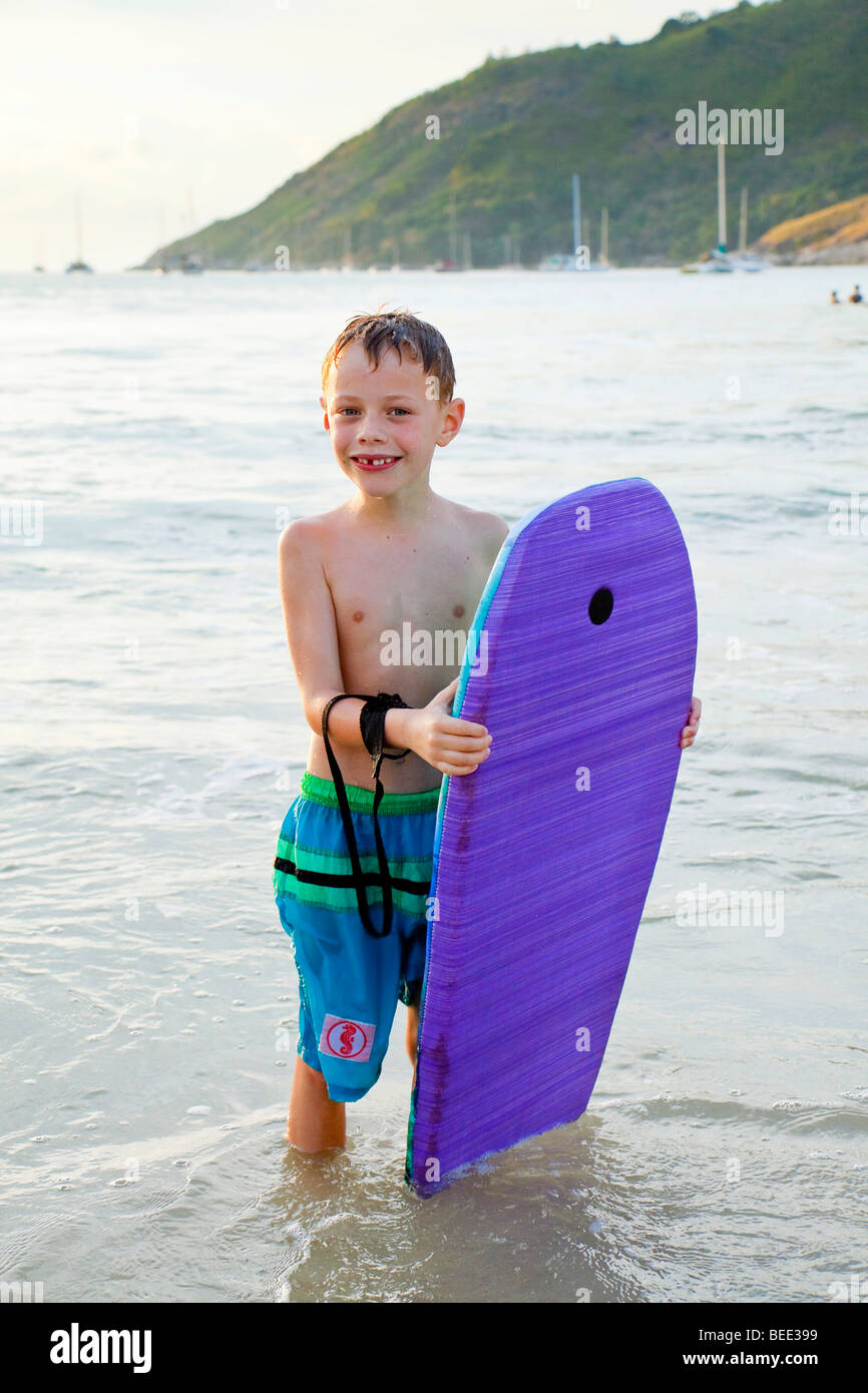 6yearold boy holding a kickboard Nai Harn Beach Phuket Island