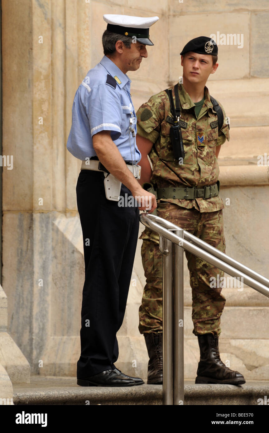 Italian policeman vigile urbano and young soldier bersagliere chat whilst on security duty at door of Milan Cathedral Italy Stock Photo