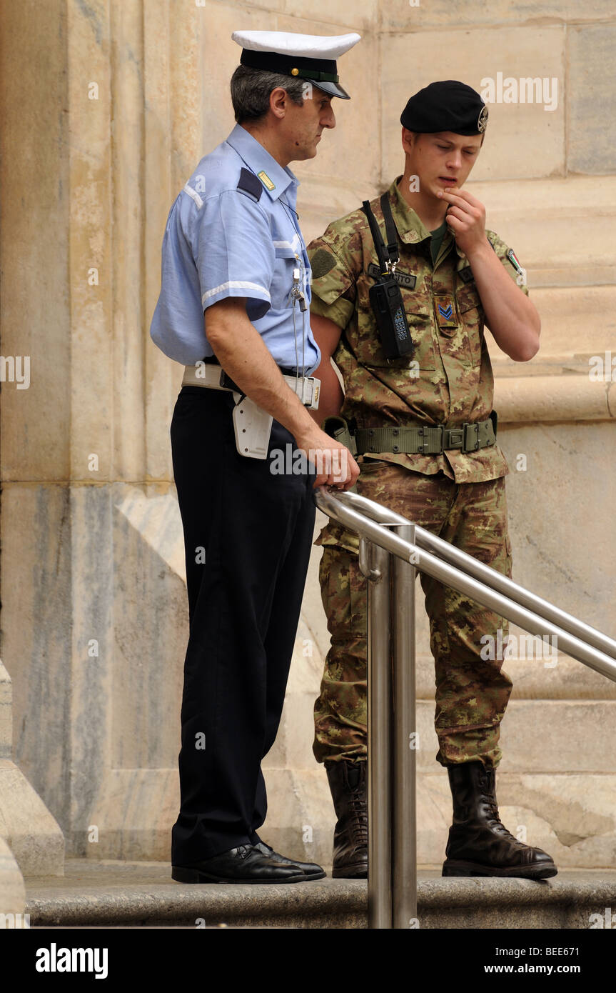Italian policeman vigile urbano and young soldier bersagliere chat whilst on security duty at door of Milan Cathedral Italy Stock Photo