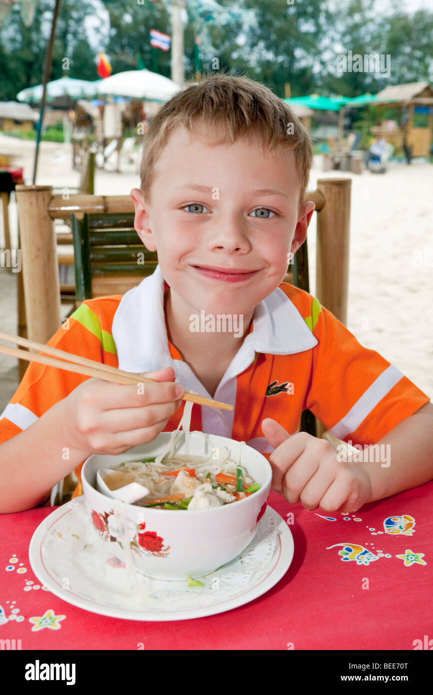 6-year-old boy eating noodle soup with chopsticks Phuket Island Southern Thailand Southeast Asia Stock Photo