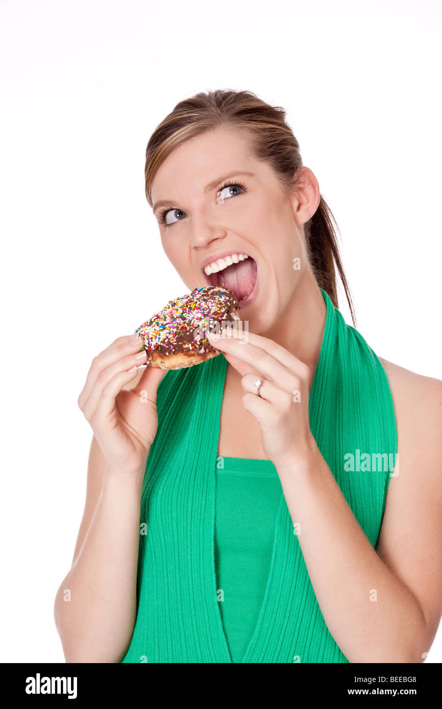 Cute Caucasian woman eating a donut on a white background Stock Photo