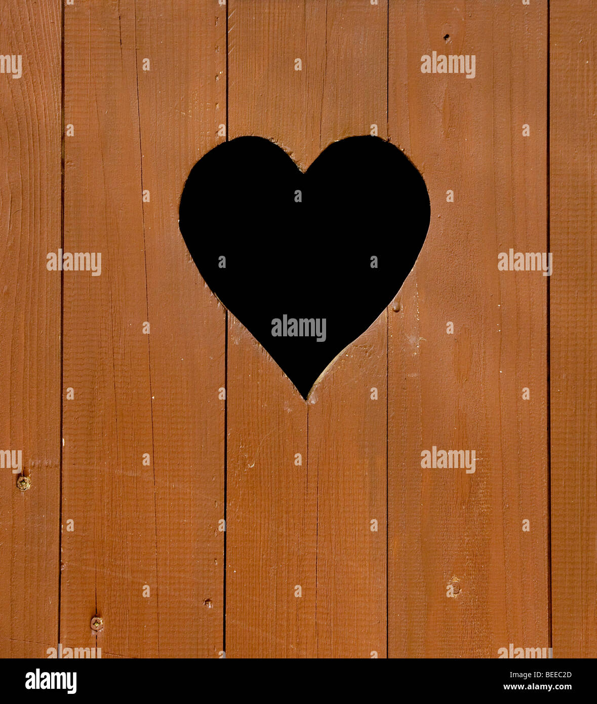 Wooden door of a toilet hut, heart-shaped window, close-up Stock Photo