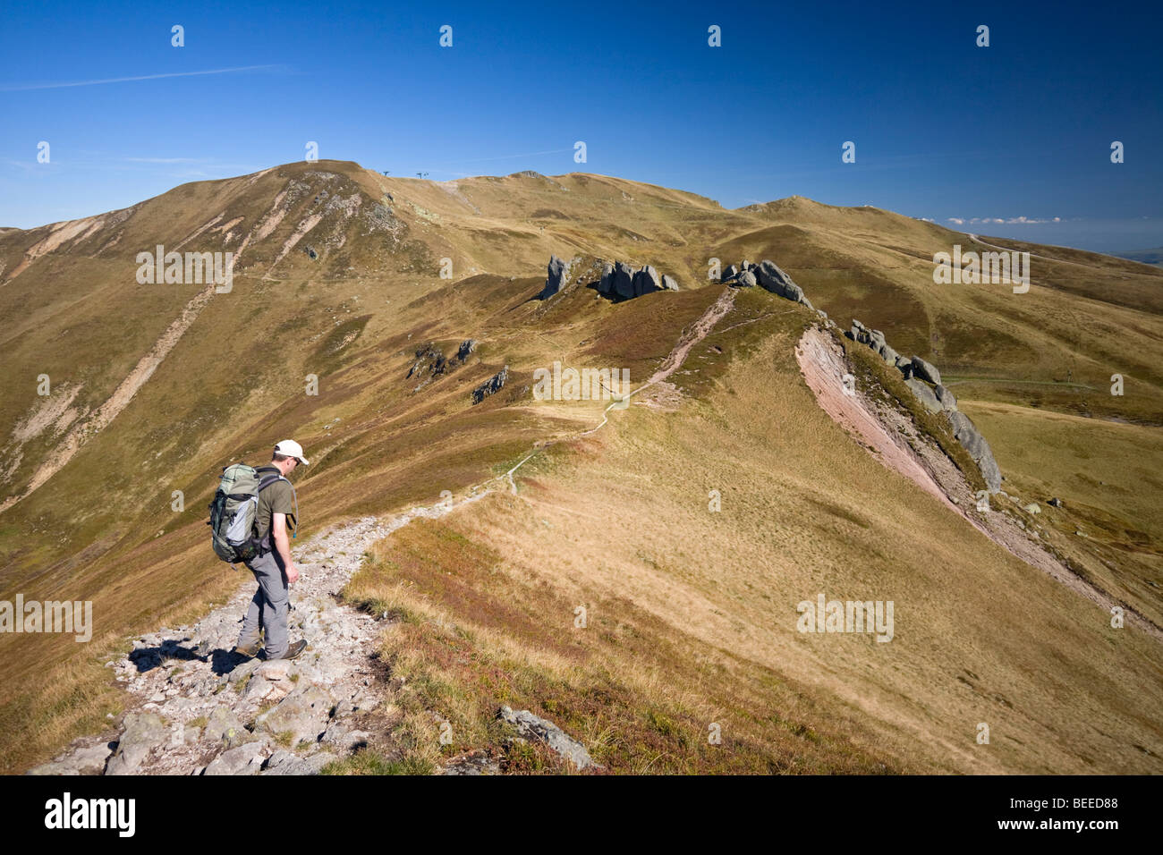 In Autumn, a lone hiker on the Sancy Massif crests (Puy de Dôme France). Randonneur solitaire sur les crêtes du Massif du Sancy. Stock Photo