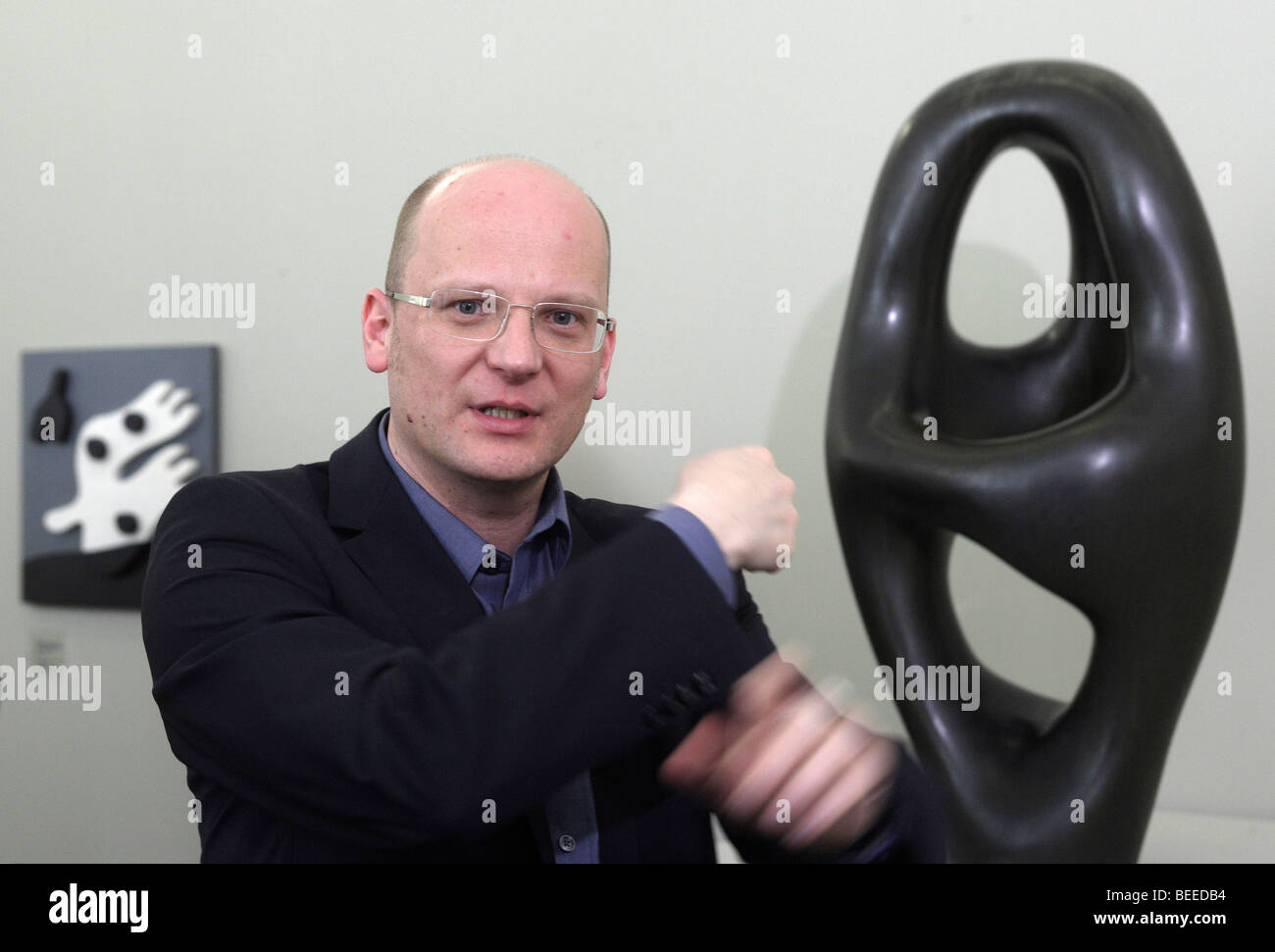 Oliver Kornhoff, director of the Arp-museum Remagen Rolandseck, bronze sculpture by Hans Arp at back entitled "Ptolemaeus I" of Stock Photo