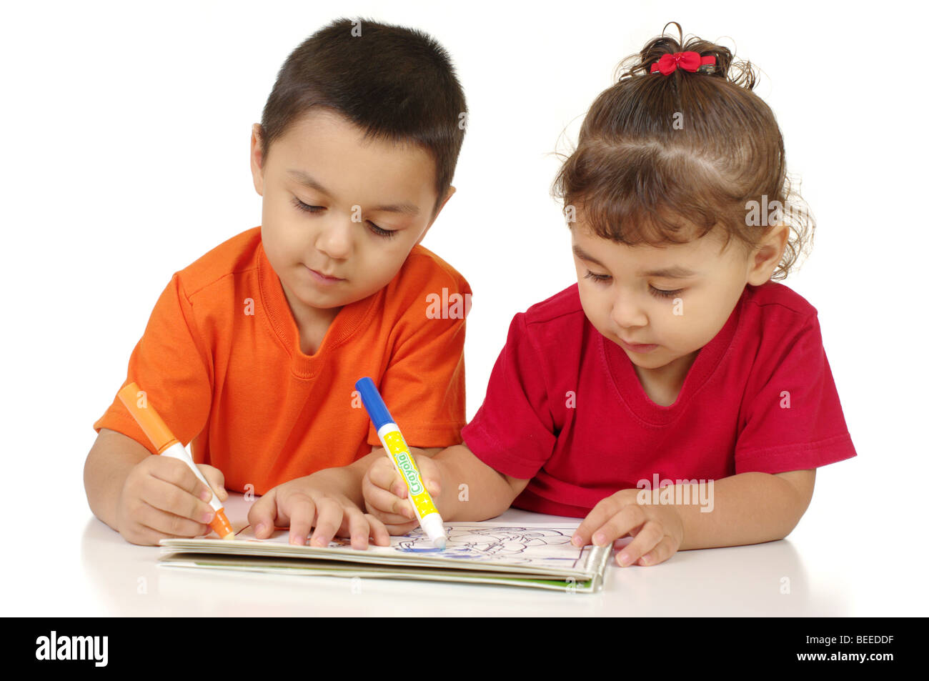A little boy and girl coloring with markers, one labeled Crayola Stock Photo