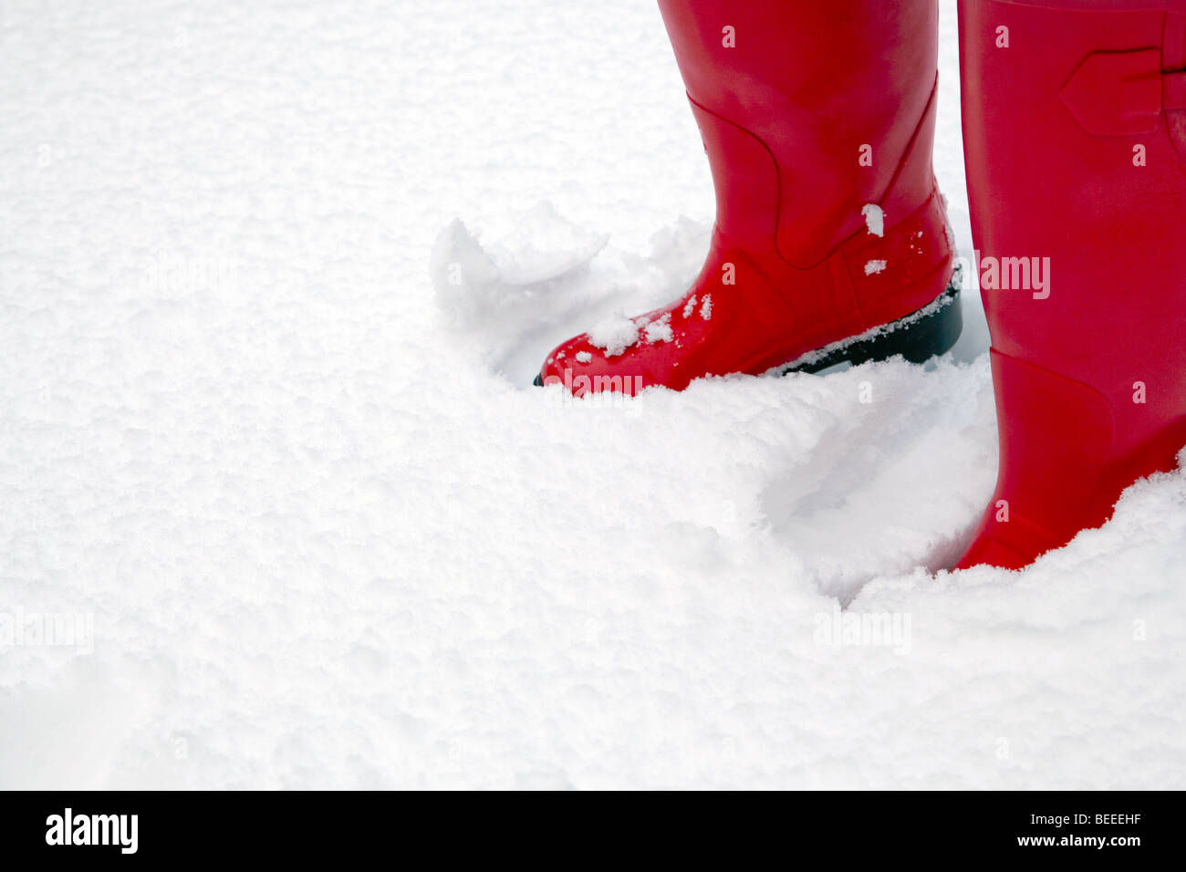 A pair of red wellington boots in some fresh snow plenty of copy space Stock Photo