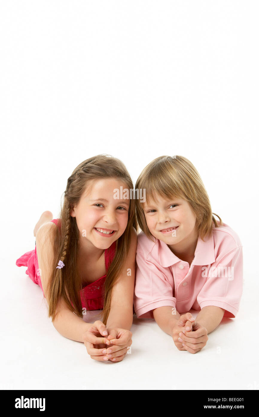 Two Children Laying on Stomach in Studio Stock Photo