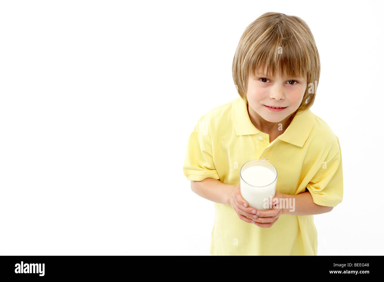 Studio Portrait of Smiling Boy Holding Glass of Milk Stock Photo