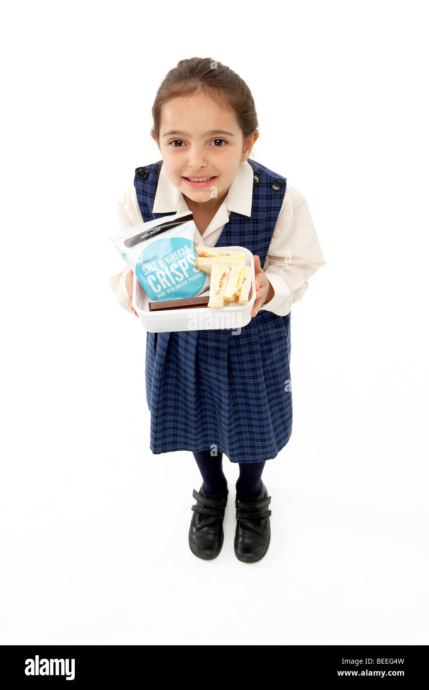 Studio Portrait of Smiling Girl Holding Lunchbox Stock Photo