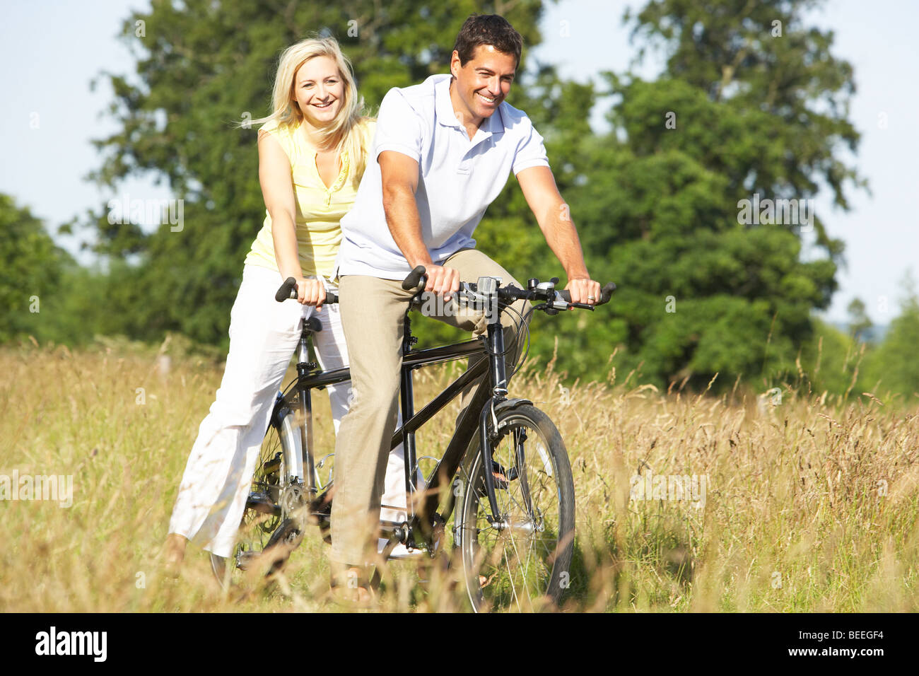 Couple riding tandem in countryside Stock Photo