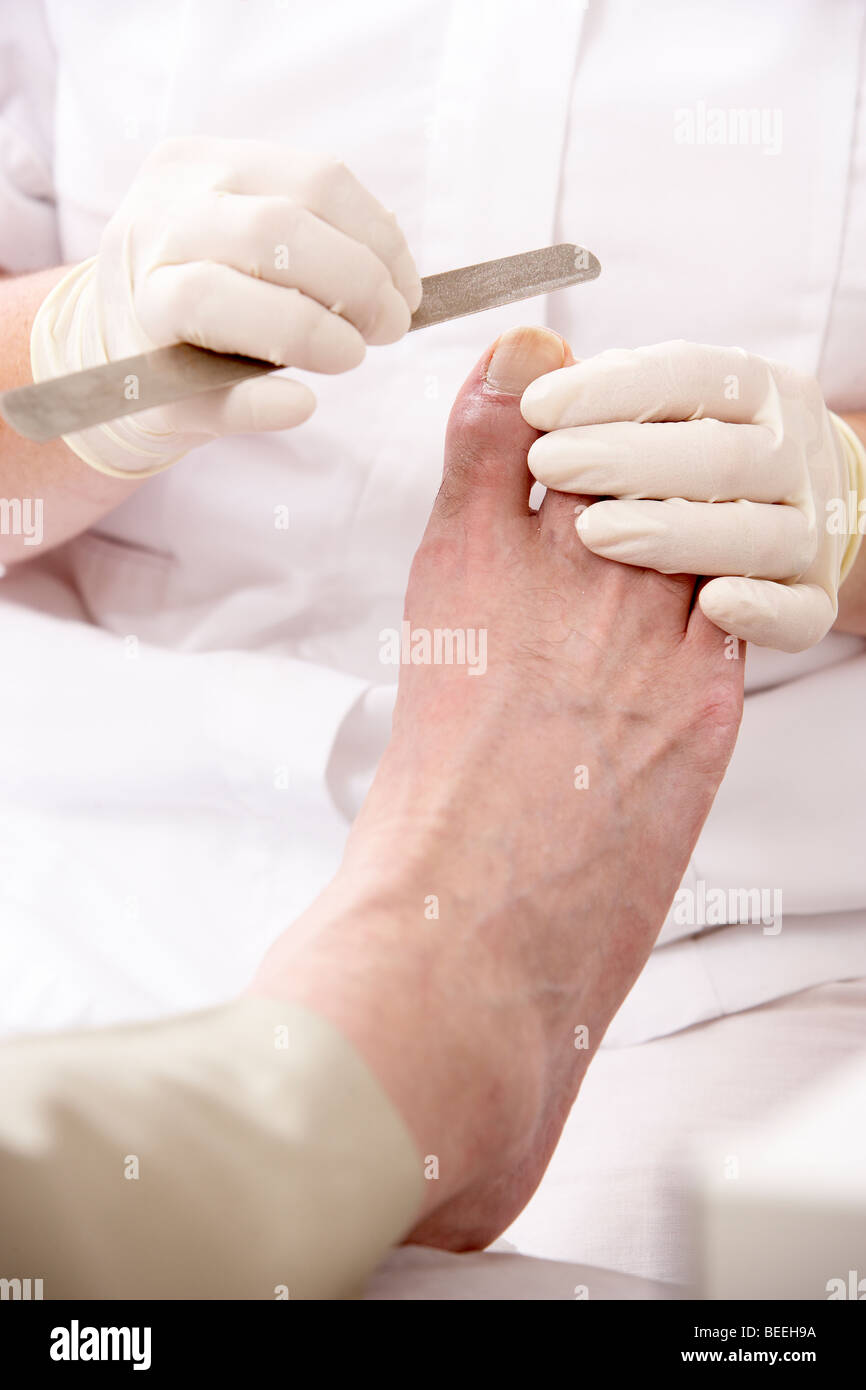 Chirpodist treating client in clinic Stock Photo