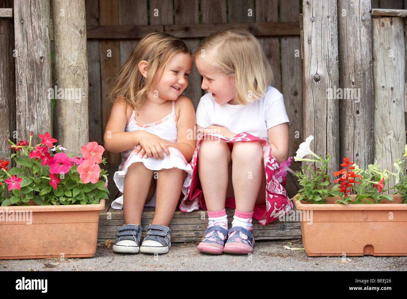 Two Young Girls Playing in Wooden House Stock Photo