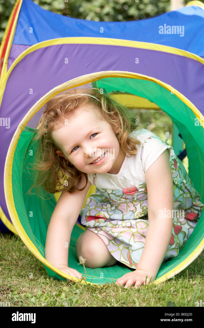 Young Girl Crawling Through Play Equipment Stock Photo