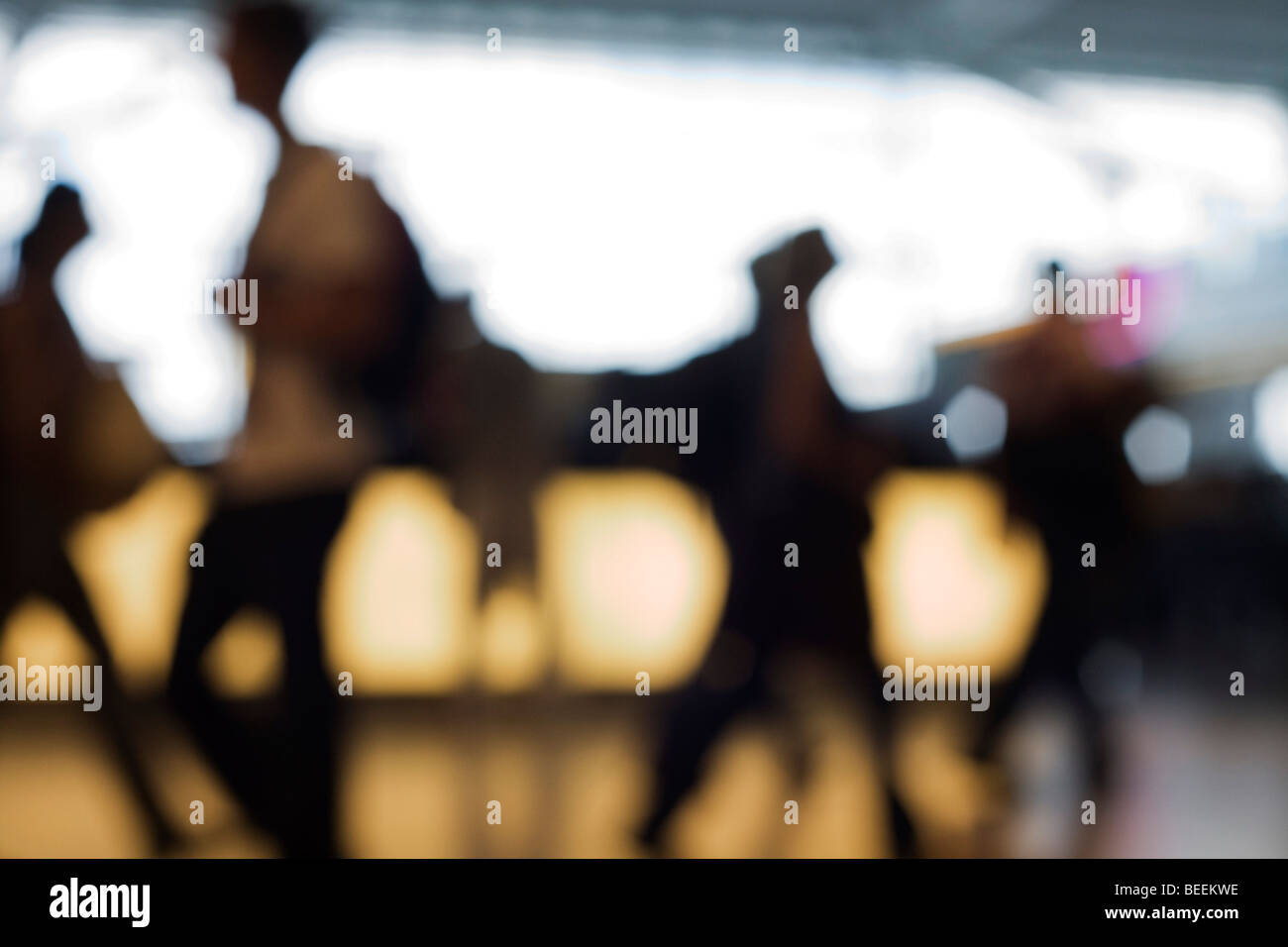 Out of focus, anonymous passengers pass-by against strong back light in Departures at Heathrow Airport's Terminal 5 Stock Photo