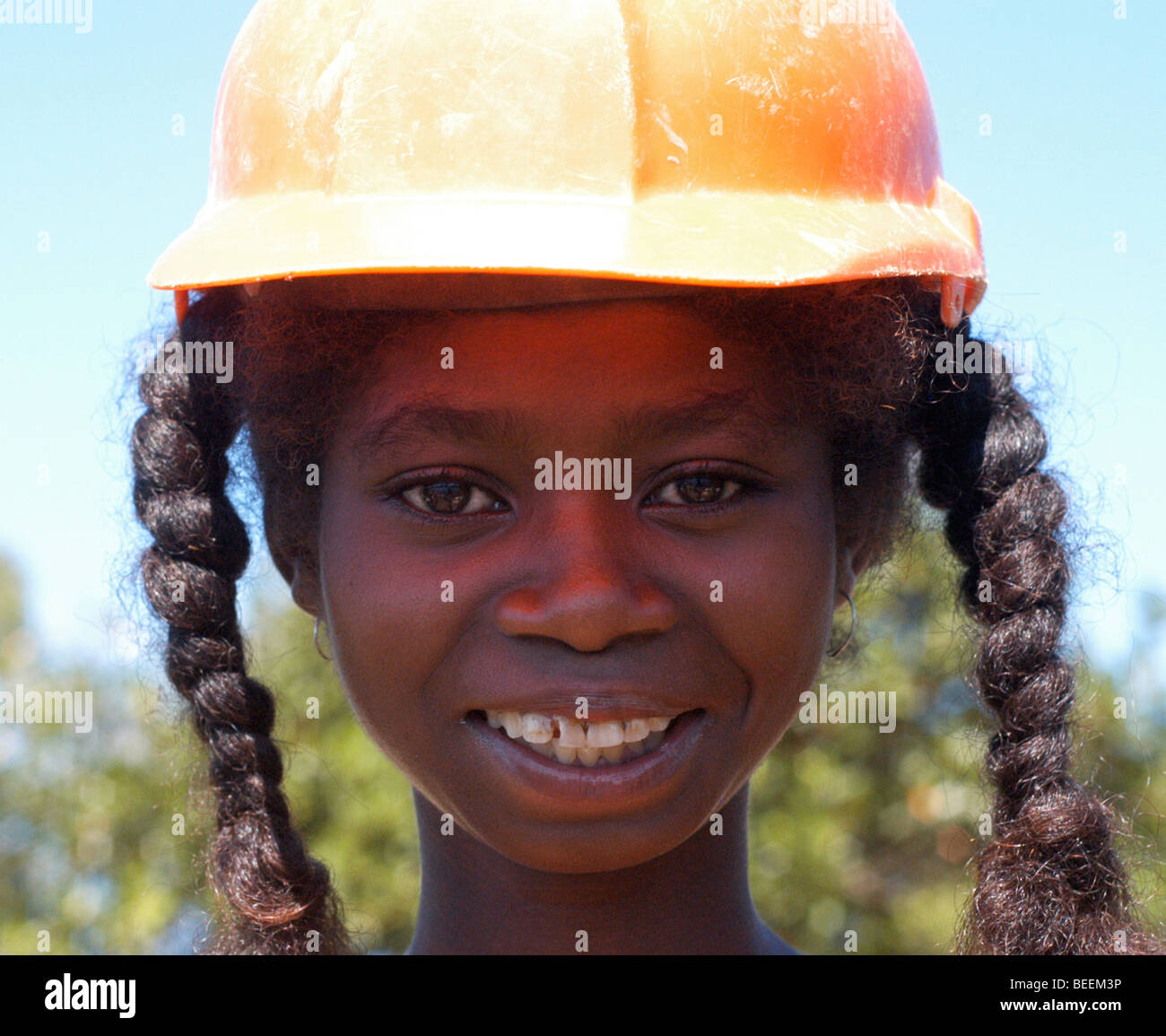 Madagascar - Smiling village girl wearing a safety helmet at the Anosy village of Agnena. Stock Photo