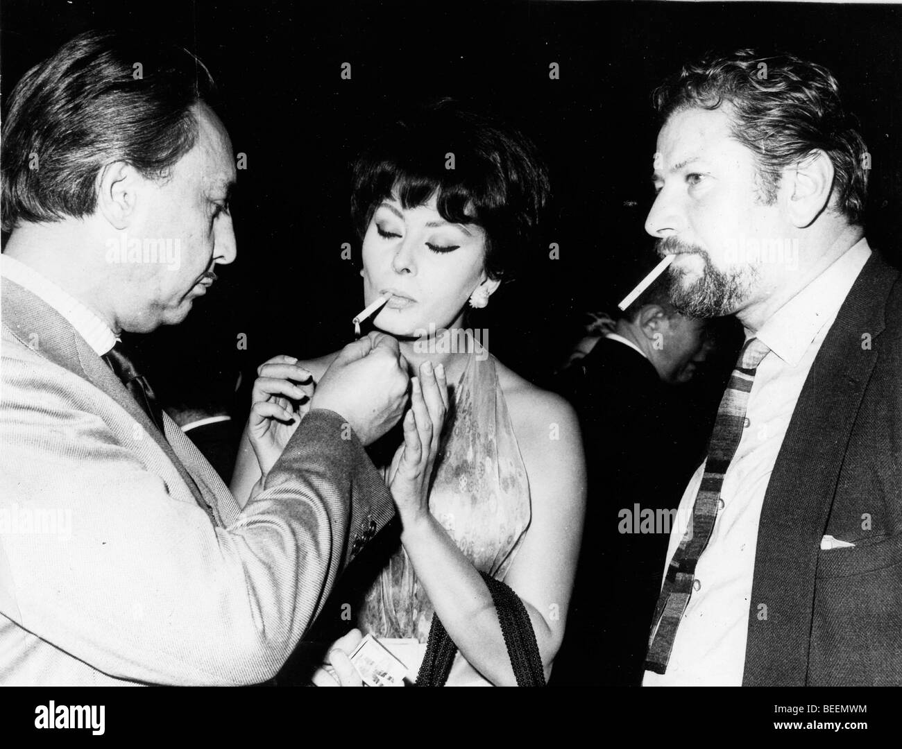 Actress Sophia Loren getting a light from Romain Gary with Peter Ustinov Stock Photo