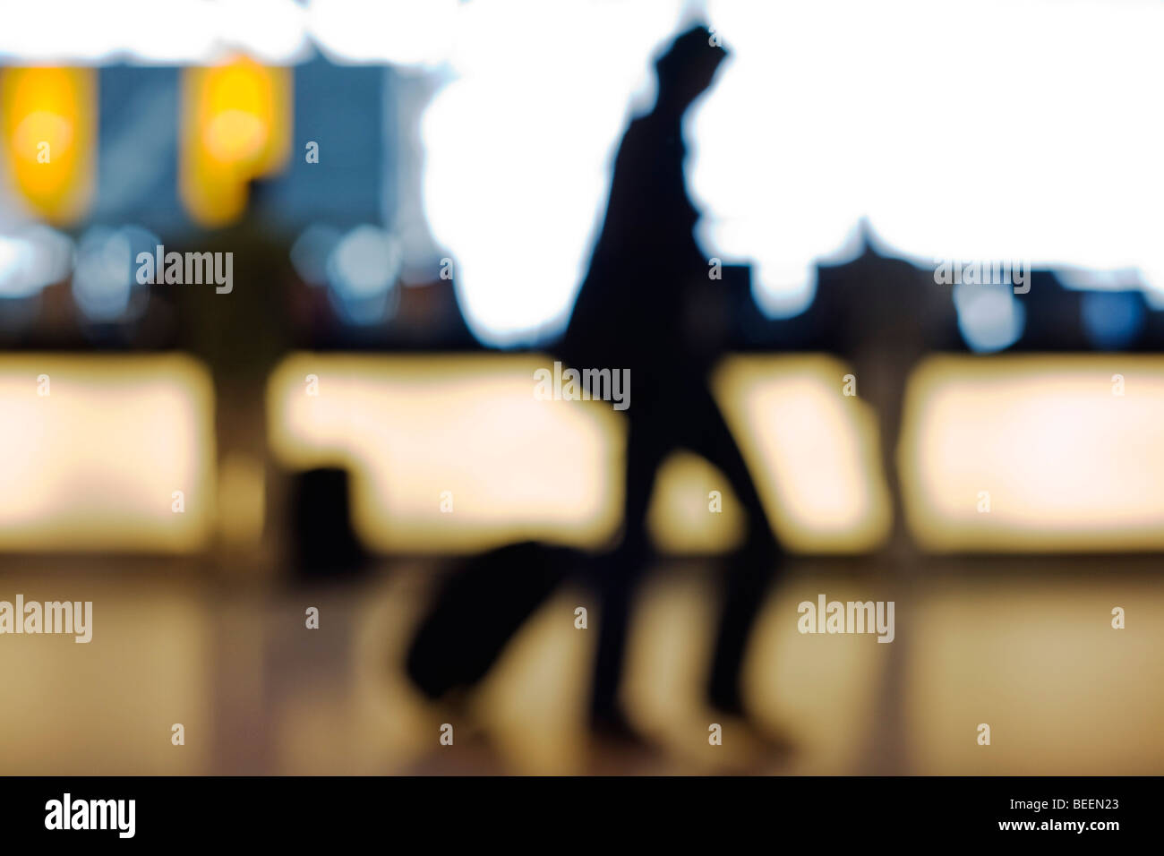 Out of focus, anonymous passengers pass-by against strong back light in Departures at Heathrow Airport's Terminal 5 Stock Photo