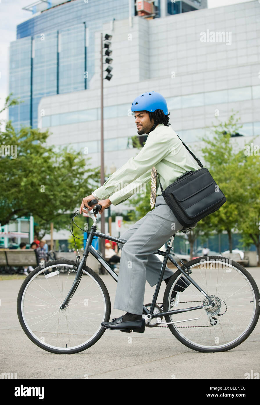 Mixed race man riding bicycle in city Stock Photo