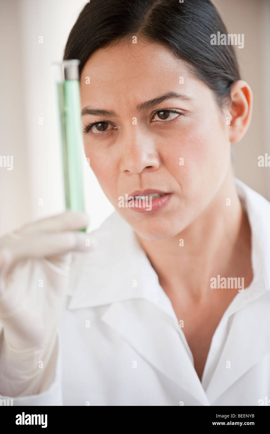 Hispanic scientist holding vial of liquid Stock Photo