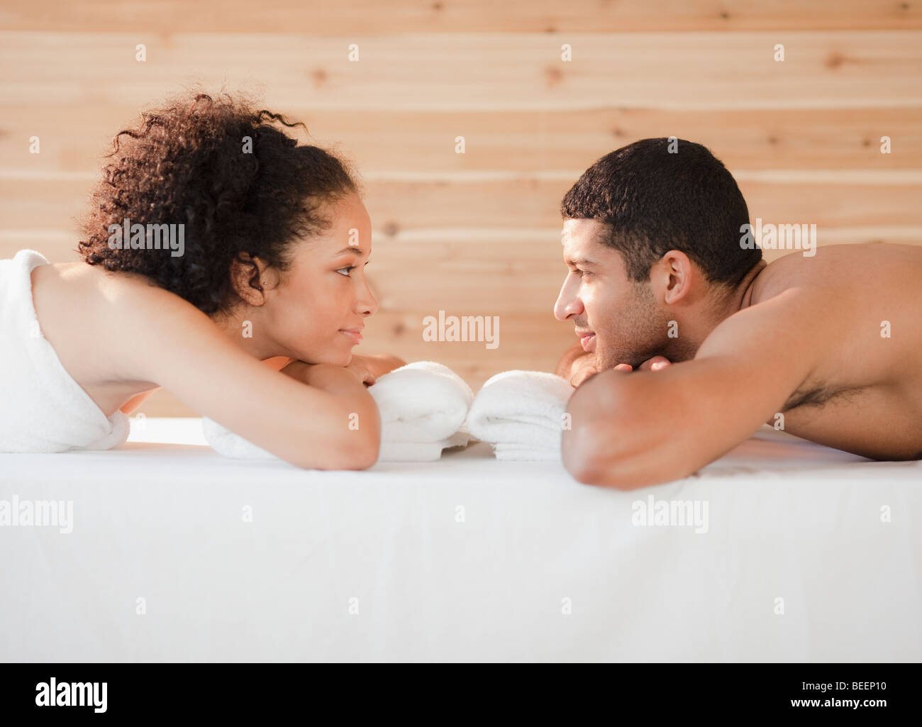 Couple laying face to face on massage table Stock Photo