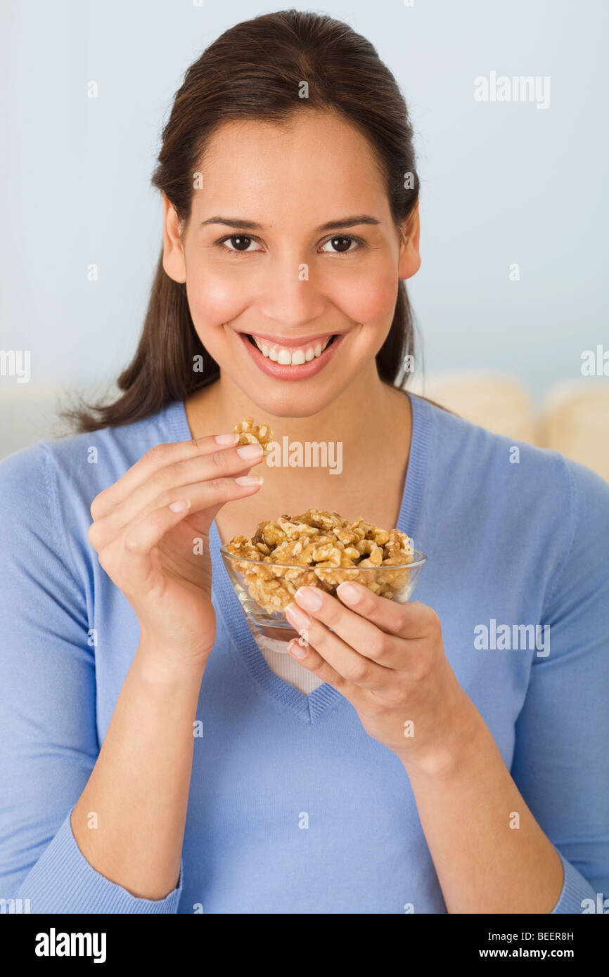 Hispanic woman eating walnuts Stock Photo