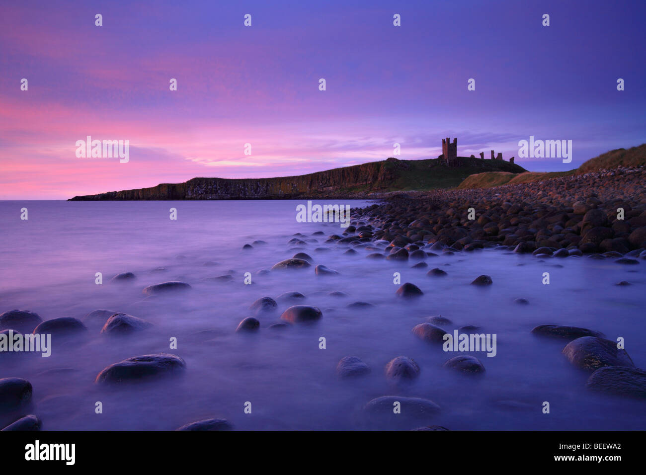 'Dunstanburgh Castle' Sunrise 'boulders'. Embleton Bay, Northumberland, England, UK Stock Photo