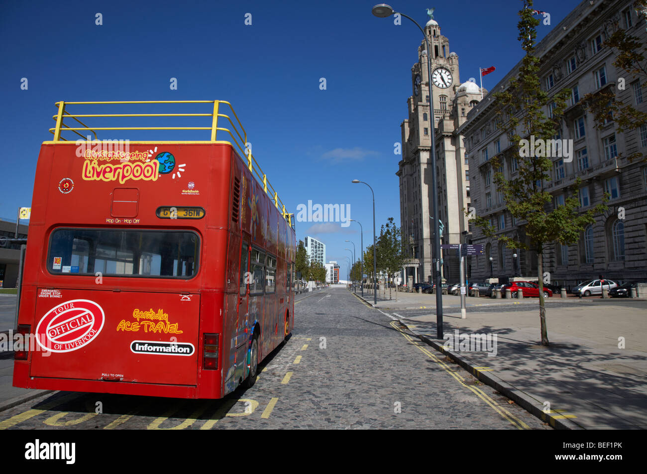 red sightseeing liverpool tour bus on canada boulevard in front of the the cunard building one of liverpools three graces Stock Photo