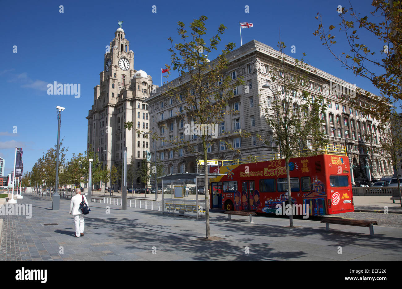 red sightseeing liverpool tour bus on canada boulevard in front of the the cunard building one of liverpools three graces Stock Photo