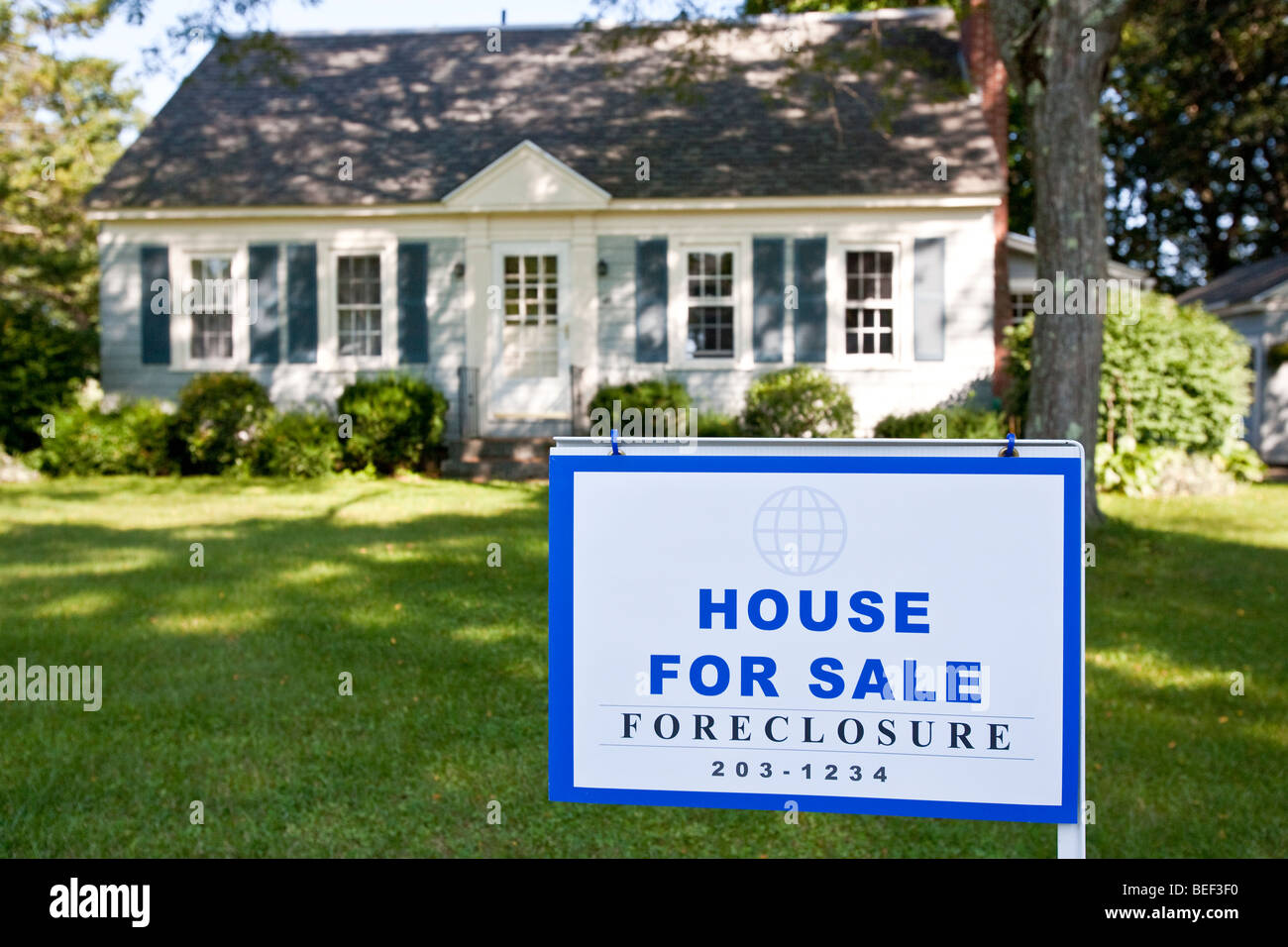 An empty home with a Foreclosure sign posted in front. Stock Photo