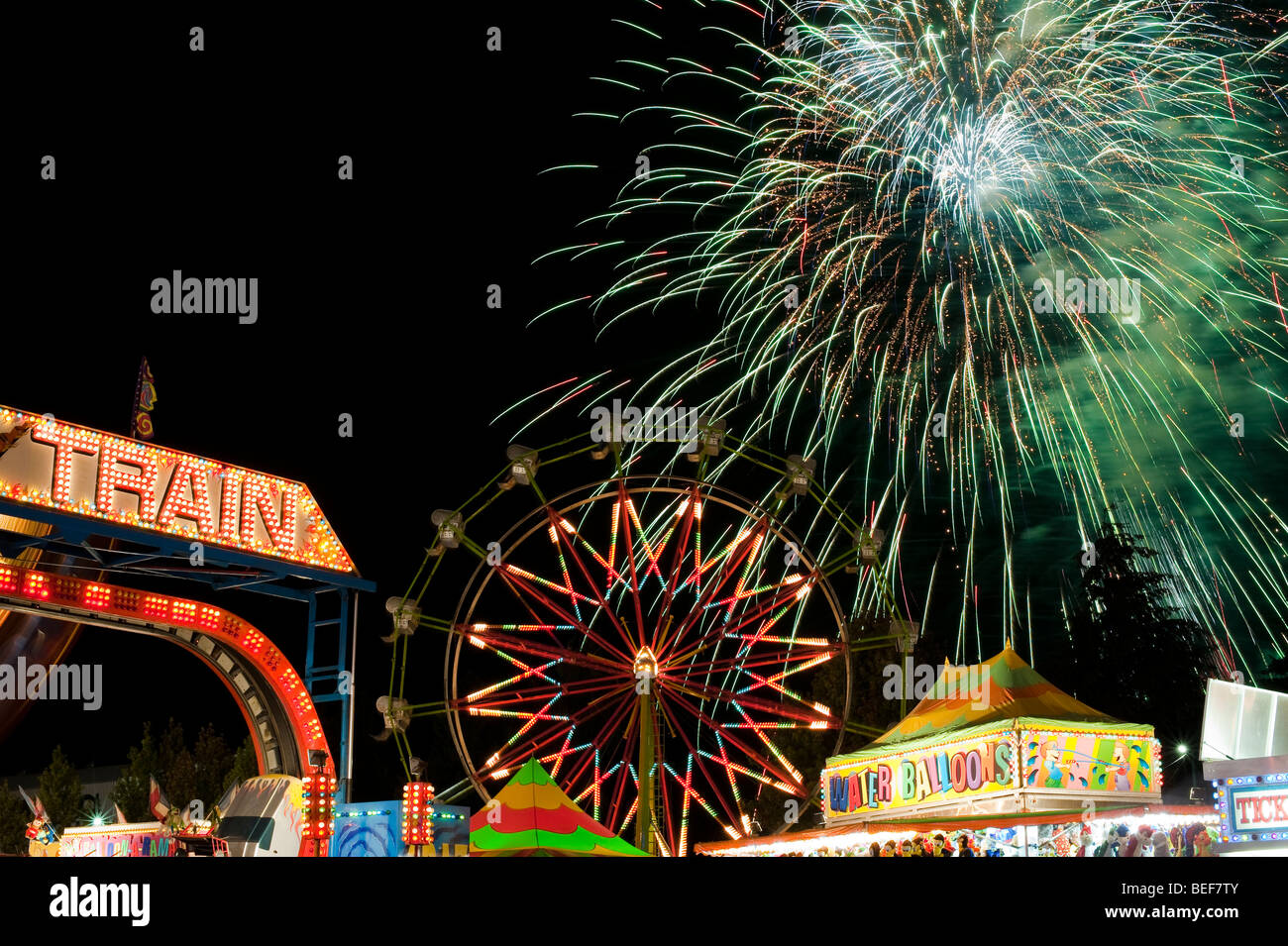 Evergreen State Fair ferris wheel at night with rides and motion with