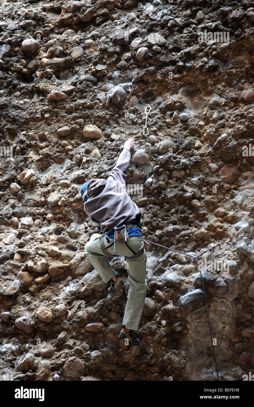 A rock climber ropes on a high rock ledge in central Utah. Steep climb