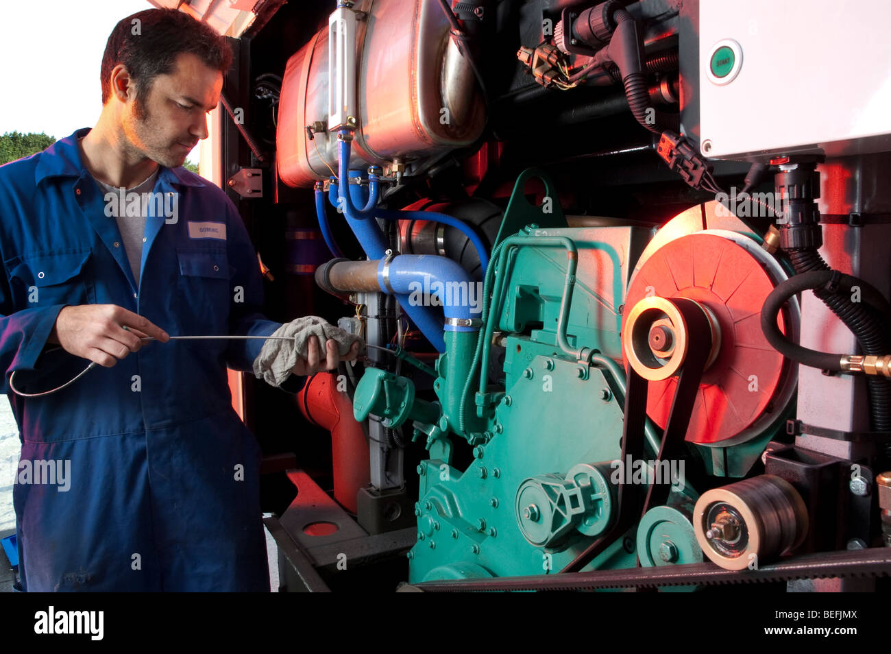 Motor mechanic using computer to set up and diagnose a coach engine Stock Photo
