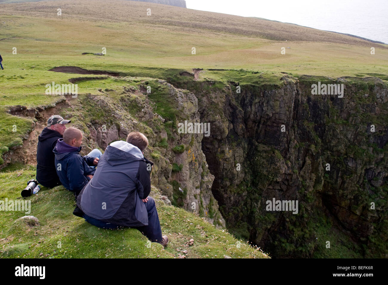 People at cliff edge on Fair Isle Shetland Stock Photo