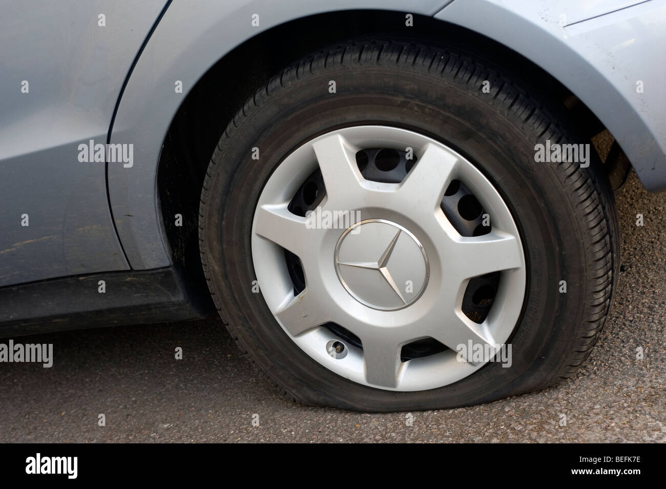 Car with a flat tyre. Stock Photo