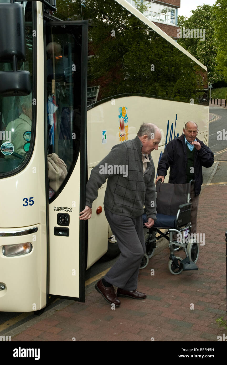 senior, elderly and disabled people boarding a coach on holiday Stock
