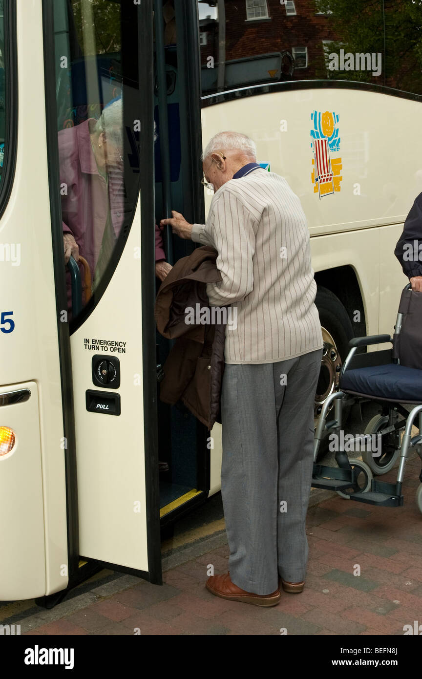 senior, elderly and disabled people boarding a coach on holiday Stock