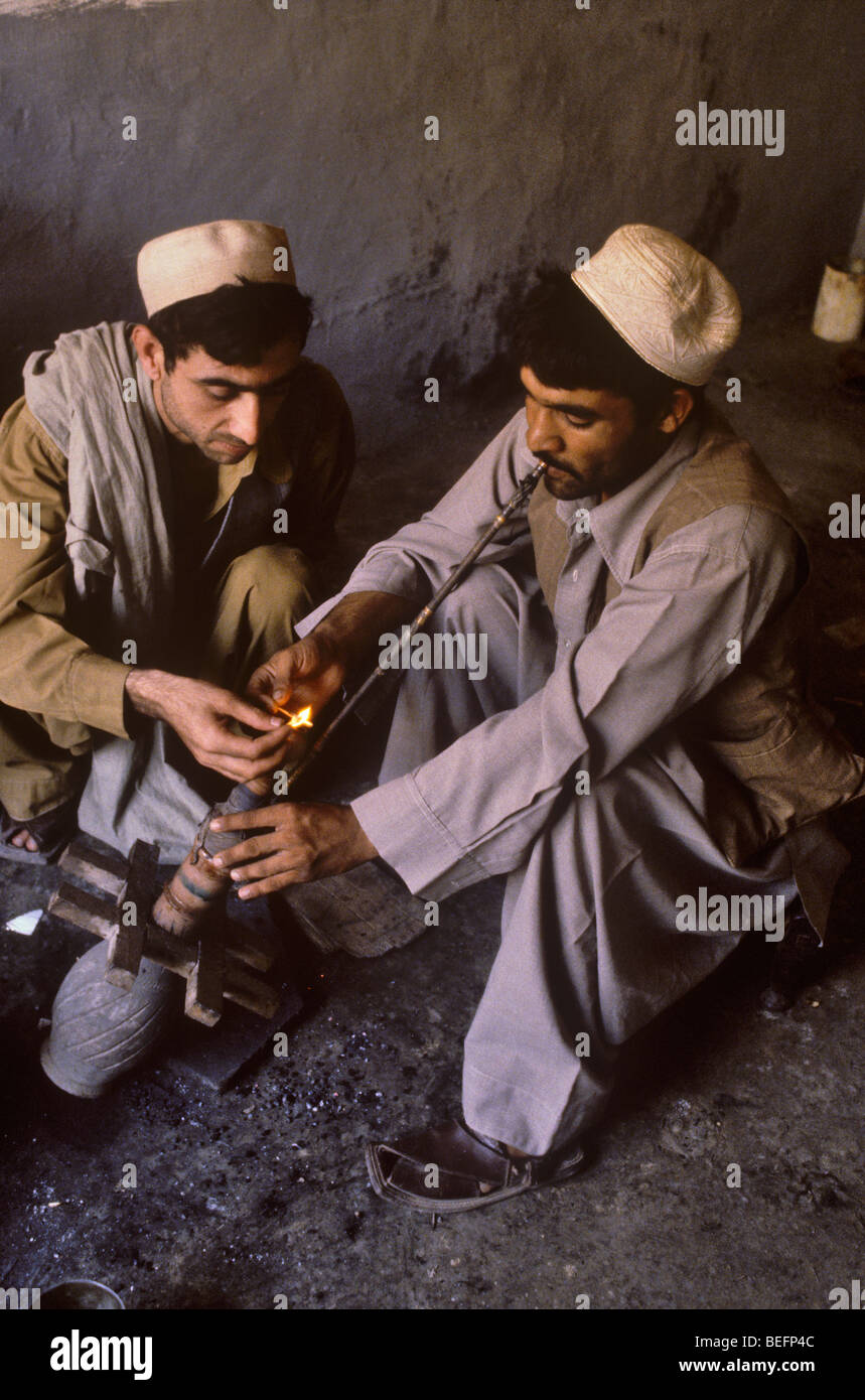 Men smoking hashish in drug shop at Landi Kotal, Pakistan Stock Photo
