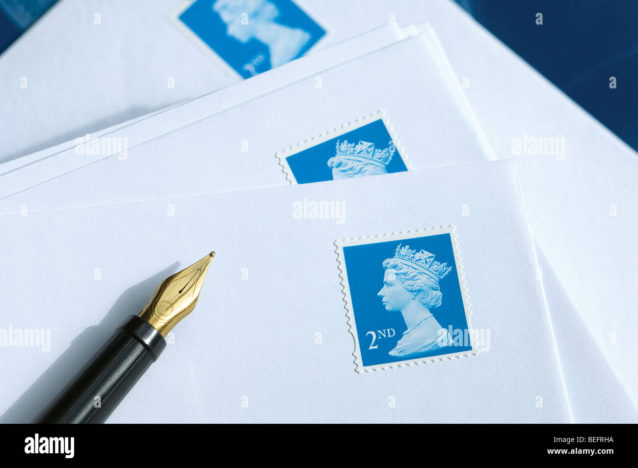 Second class British stamps on envelopes with a fountain pen close up