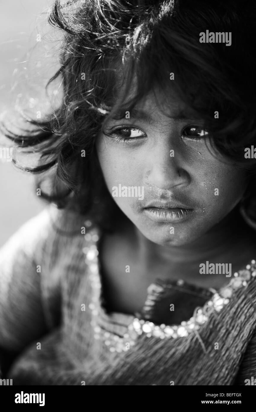 Young Indian street girl daydreaming in black and white. Selective focus Stock Photo
