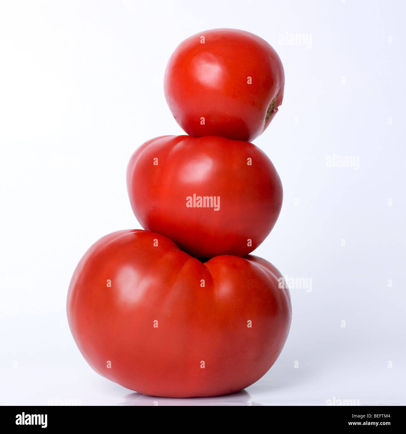 Three tomatoes on a white background in studio Stock Photo - Alamy