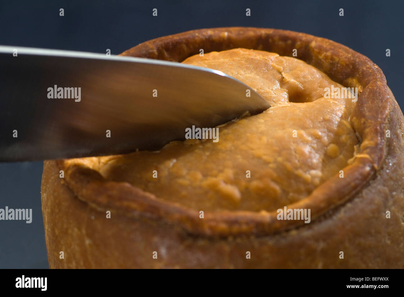 Cutting a Melton Mowbray pork pie. Stock Photo