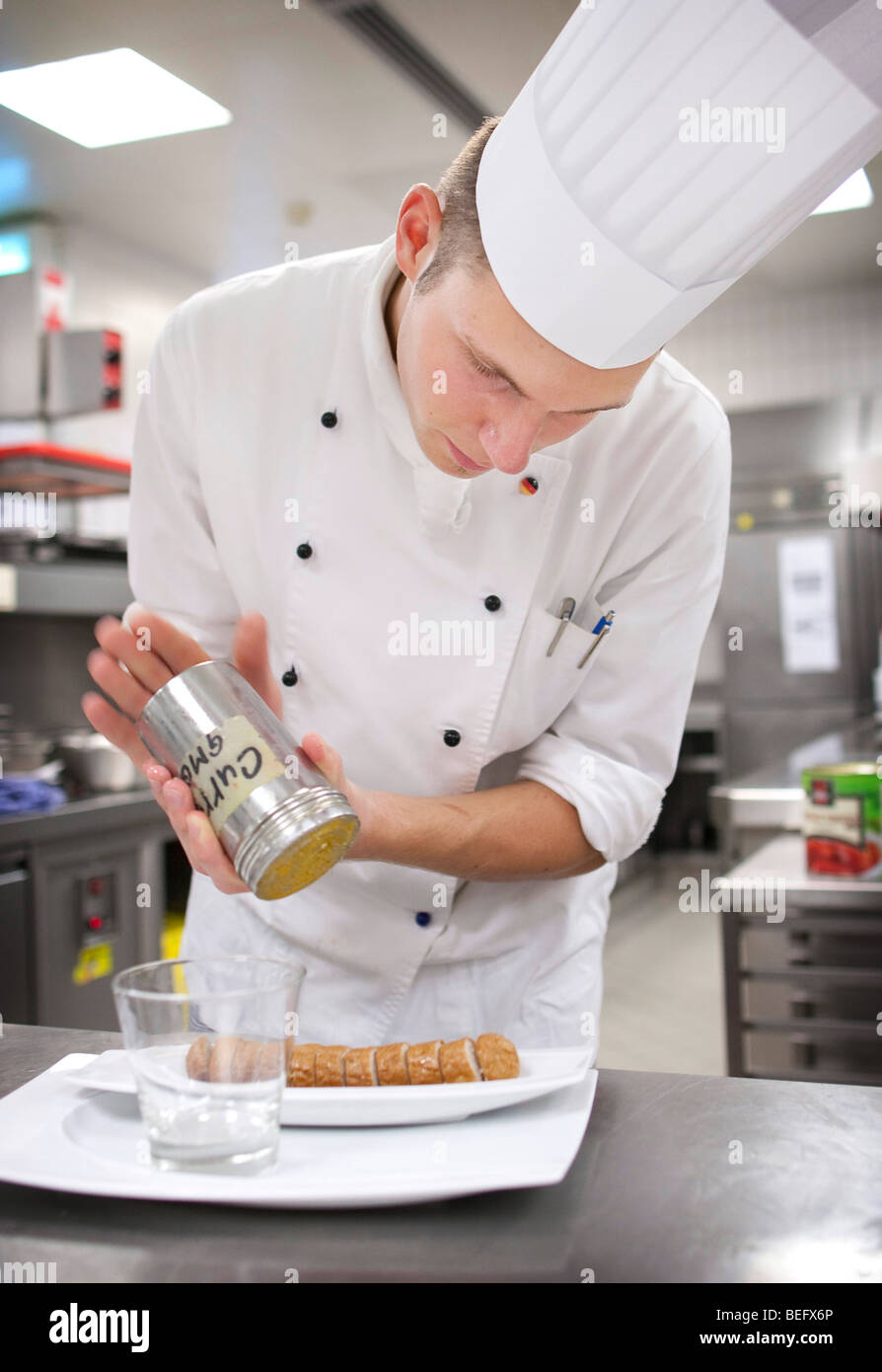 Chef in the kitchen of Hotel ADLON in Berlin prepares a curried sausage Stock Photo