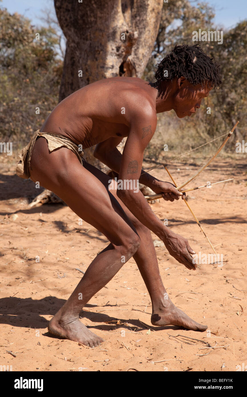 San village in Namiba on the edge of the Kalahari desert. A San hunter with bow and arrow. Stock Photo