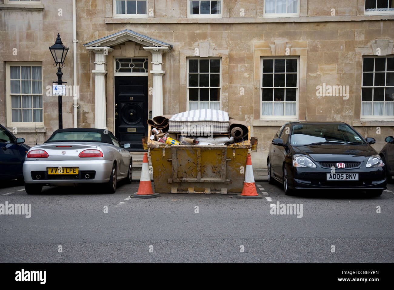 Builders Skip Parked In A Car Parking Space Stock Photo
