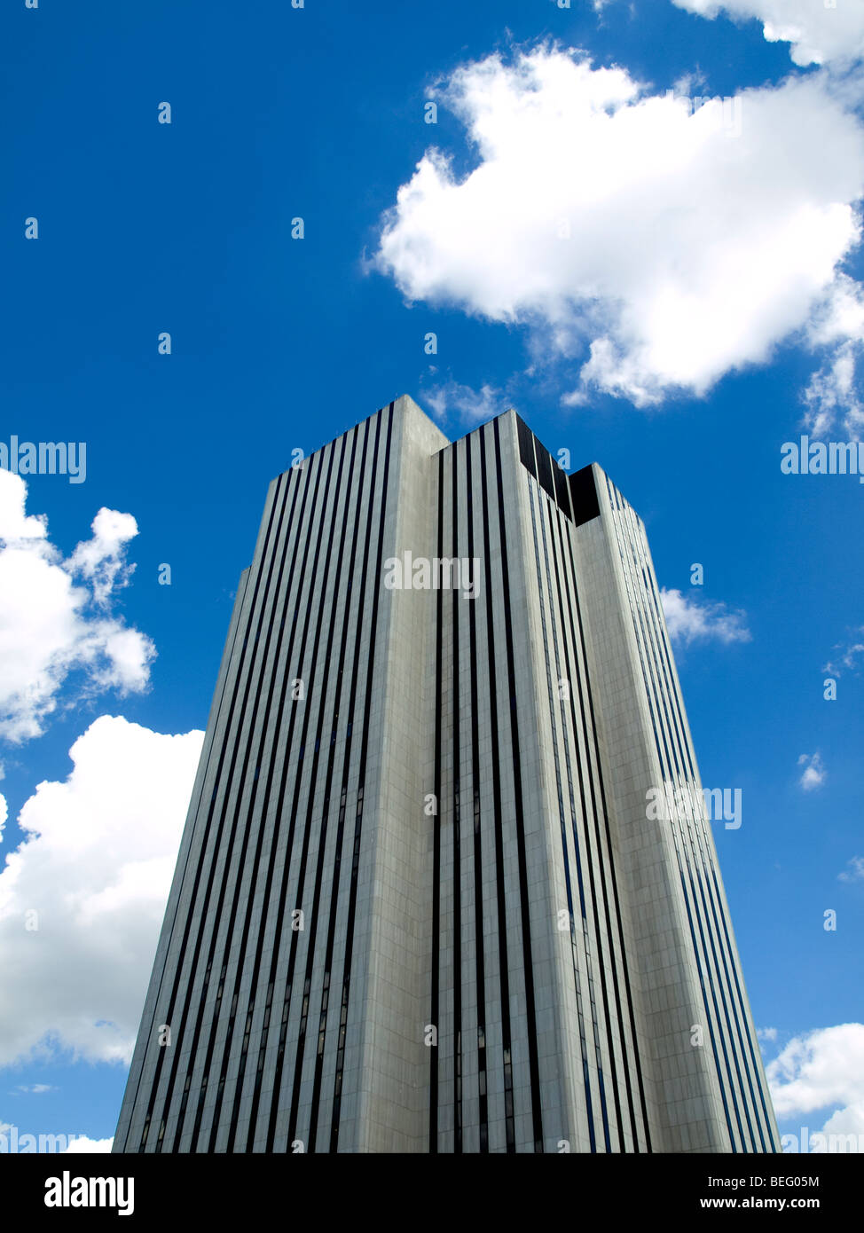 High modern skyscraper on a background of a blue sky and clouds. Stock Photo